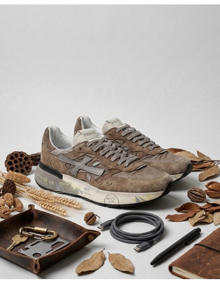 Premiata en ante marrón modelo mick 018437 vista lateral de los dos pies sobre hojas secas