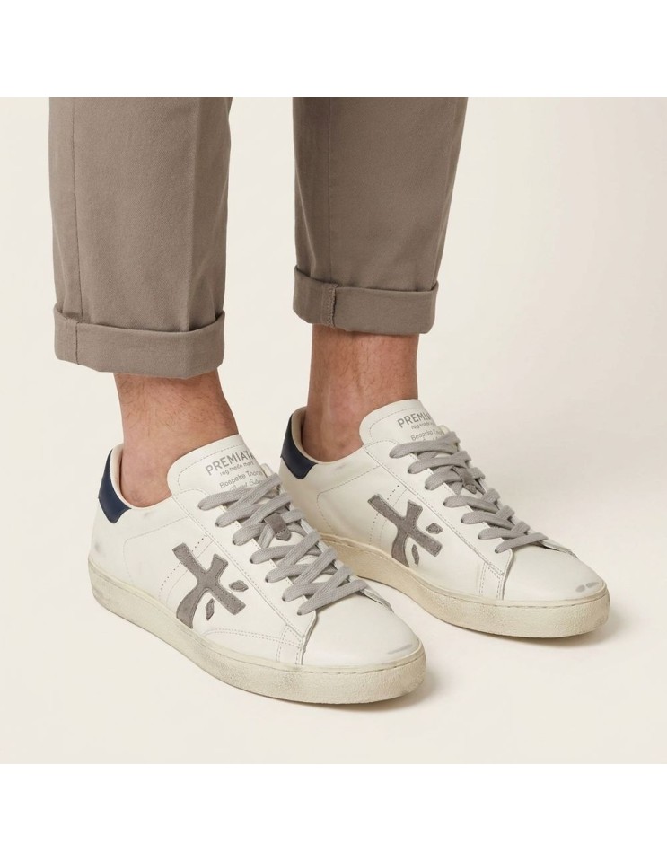 Premiata Steven Print Edition blanco talonera azul y logo gris steven 8479 puesta en los pies con un pantalón remangado