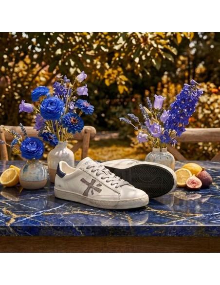 Premiata Steven Print Edition blanco talonera azul y logo gris steven 8479 vista sobre mesa