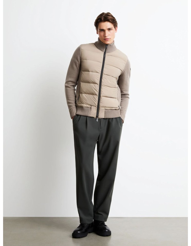 Chaqueta híbrida RRD de plumón de pato 90/10 con mangas de lana y cachemira puesta en un hombre con pantalones gris